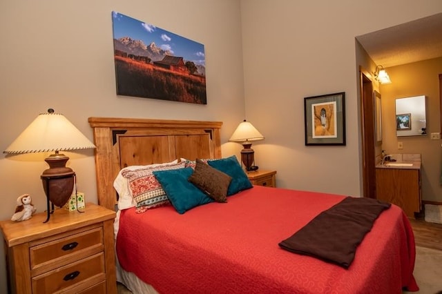 bedroom featuring ensuite bath, sink, and carpet