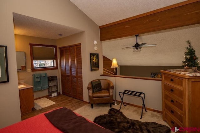 bedroom featuring a closet, a textured ceiling, lofted ceiling, and ceiling fan