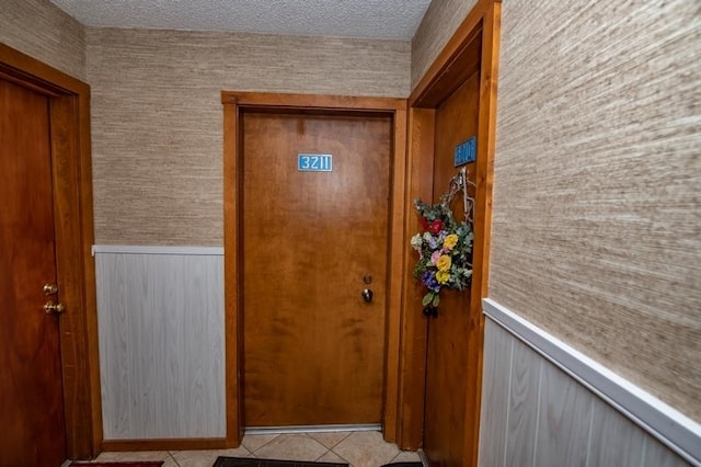 doorway to outside with light tile floors and a textured ceiling