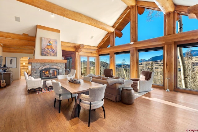 103 Double Eagle Way, Mountain Village, CO 81435 - dining room with beamed ceiling, a fireplace, a mountain view, high vaulted ceiling, and light hardwood / wood-style flooring