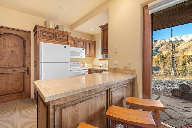 103 Double Eagle Way, Mountain Village, CO 81435 - kitchen with a kitchen breakfast bar, light stone countertops, white appliances, and kitchen peninsula