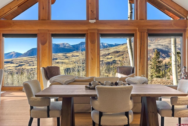 103 Double Eagle Way, Mountain Village, CO 81435 - dining room featuring a mountain view, beamed ceiling, a healthy amount of sunlight, and light hardwood / wood-style flooring