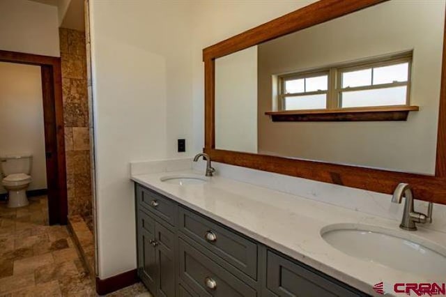 bathroom featuring dual vanity, toilet, and tile patterned floors