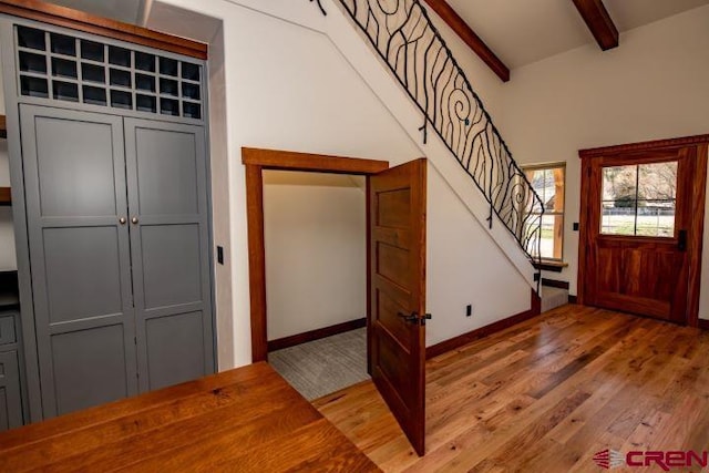 entryway with beamed ceiling, hardwood / wood-style floors, and high vaulted ceiling