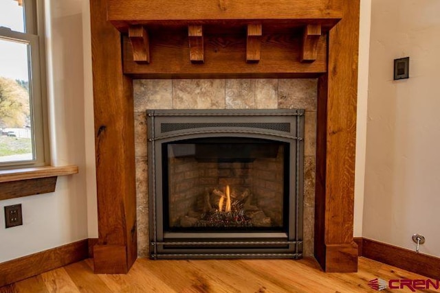 interior details with a tile fireplace and hardwood / wood-style flooring