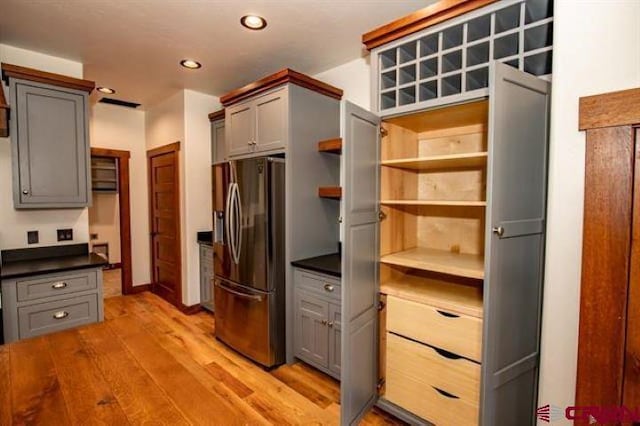 kitchen with stainless steel fridge with ice dispenser, gray cabinets, and light hardwood / wood-style flooring