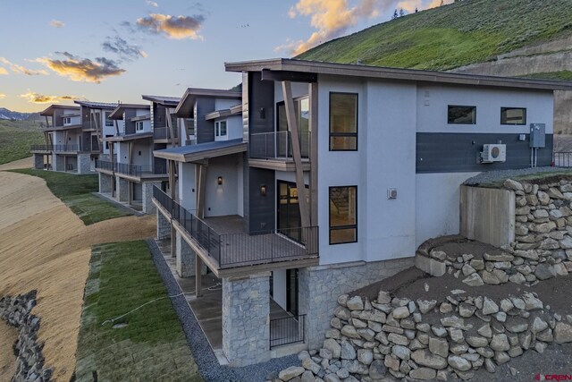 back house at dusk featuring a balcony