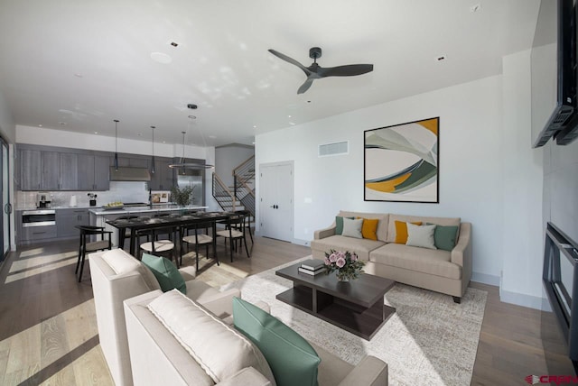 living room featuring ceiling fan and light wood-type flooring