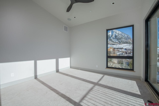 carpeted spare room featuring ceiling fan and vaulted ceiling