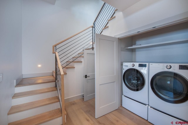 washroom with independent washer and dryer and light hardwood / wood-style flooring