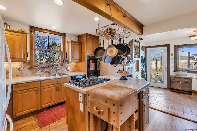 kitchen with plenty of natural light, a kitchen island, sink, and backsplash