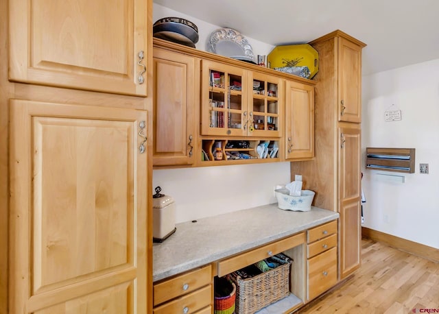 kitchen featuring built in desk and light wood-type flooring