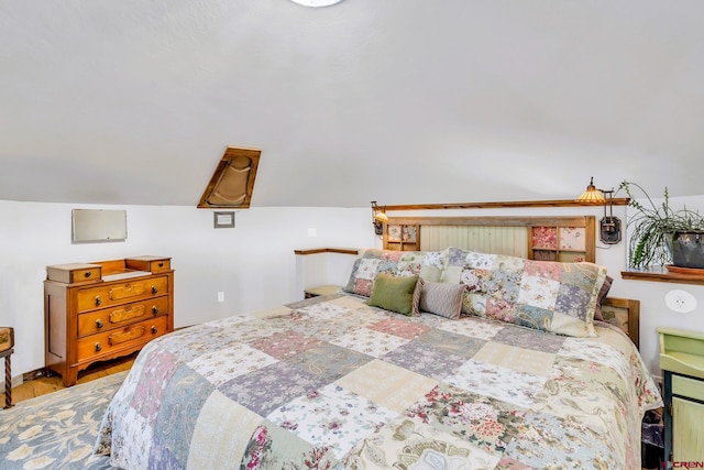 bedroom with hardwood / wood-style flooring and lofted ceiling