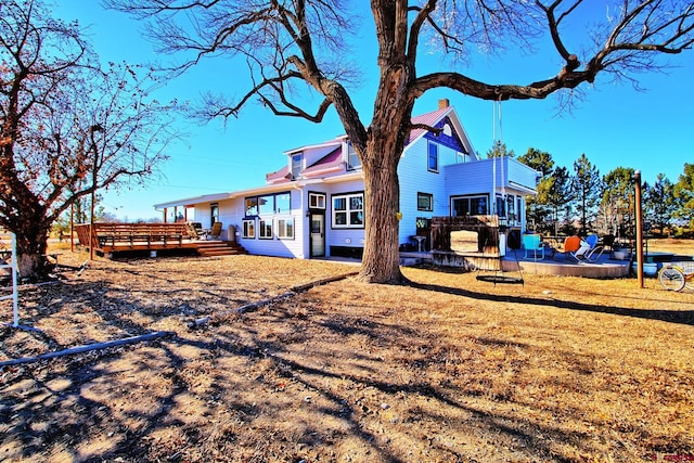 rear view of property featuring a deck