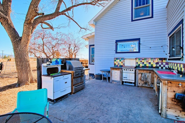 view of patio featuring exterior kitchen, sink, and a grill