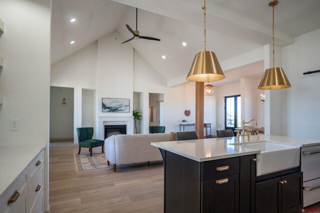 kitchen featuring ceiling fan, hanging light fixtures, light wood-type flooring, and high vaulted ceiling