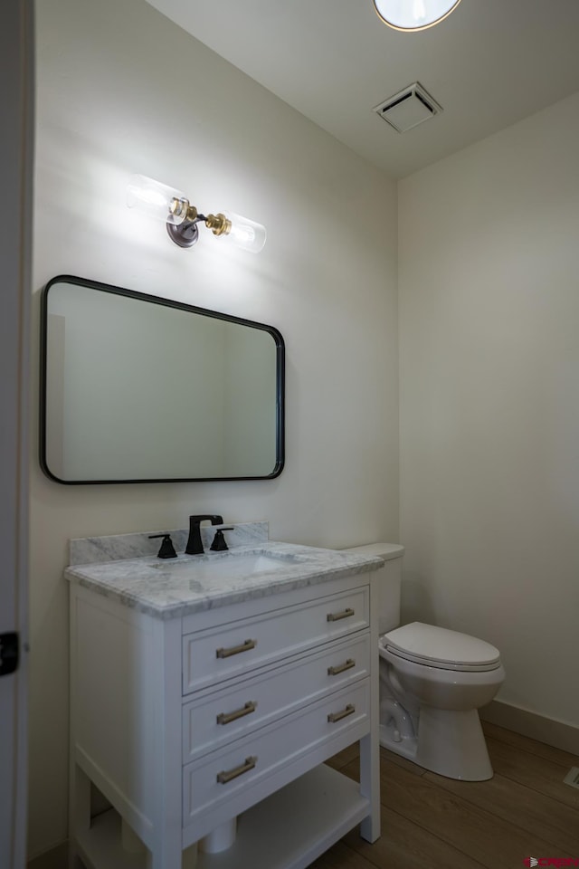 bathroom featuring vanity, toilet, and hardwood / wood-style floors