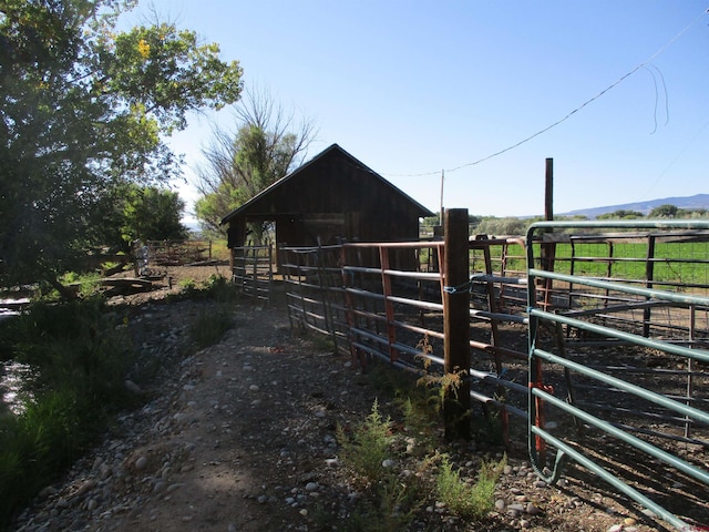 view of stable featuring a rural view and an outdoor structure