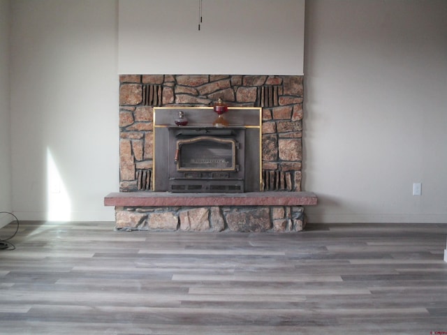 details with a wood stove and wood-type flooring