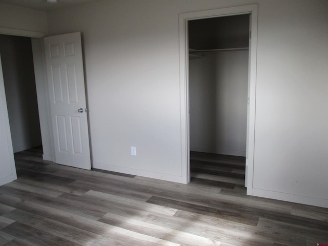 unfurnished bedroom with dark hardwood / wood-style floors and a closet