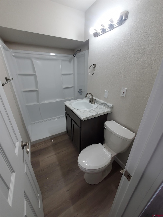 full bathroom featuring vanity, hardwood / wood-style floors, bathtub / shower combination, and toilet