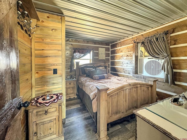 bedroom with wooden walls and dark hardwood / wood-style flooring