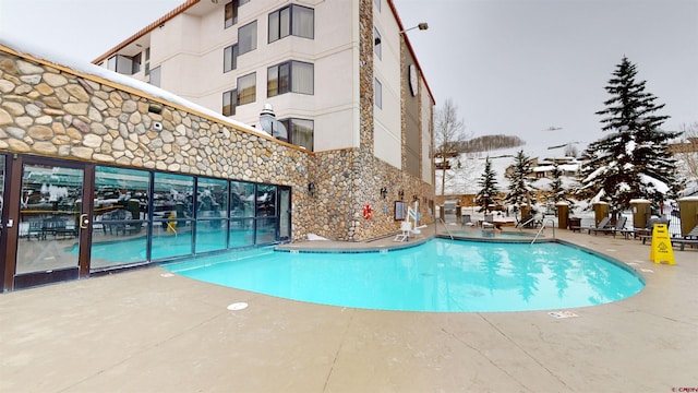 snow covered pool with a patio