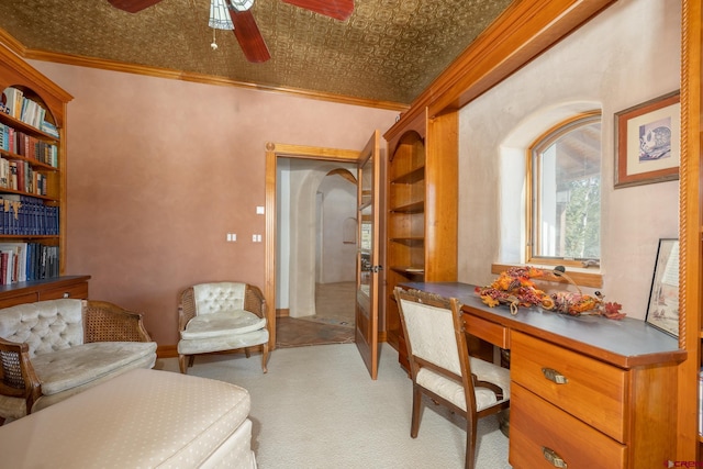 carpeted office featuring ceiling fan and crown molding