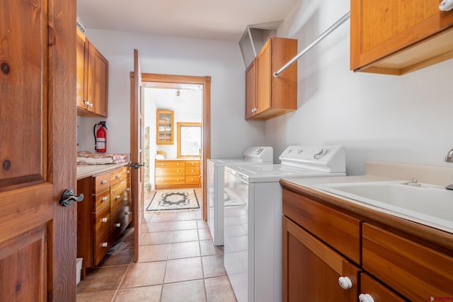 laundry area featuring light tile floors, cabinets, and independent washer and dryer