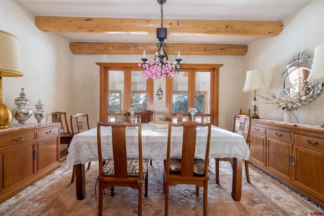 dining room with beamed ceiling and a chandelier