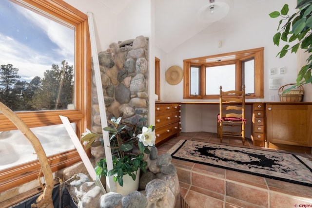 foyer featuring tile flooring, plenty of natural light, and vaulted ceiling