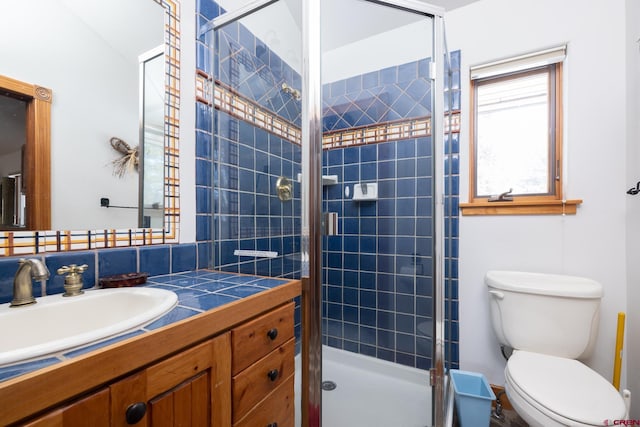 bathroom featuring walk in shower, tasteful backsplash, vanity with extensive cabinet space, and toilet