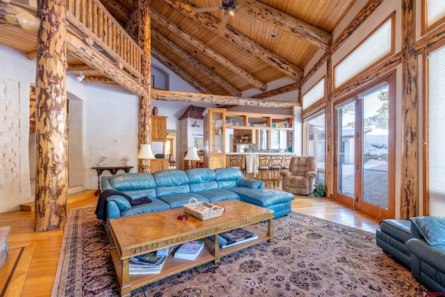 living room with ceiling fan, high vaulted ceiling, light hardwood / wood-style floors, beam ceiling, and wood ceiling