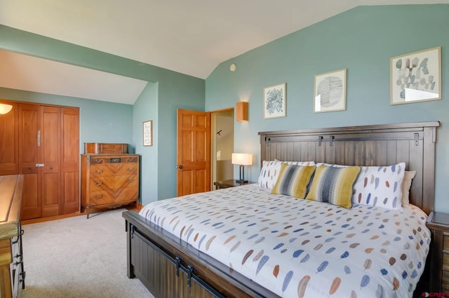 bedroom featuring lofted ceiling, a closet, and light carpet