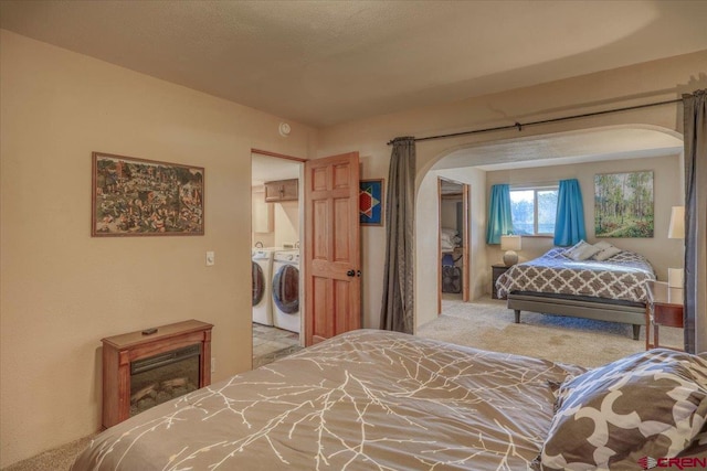 carpeted bedroom with washing machine and dryer