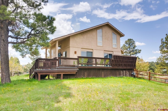 rear view of property with a wooden deck and a yard