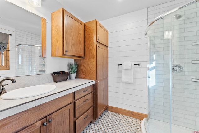 bathroom featuring a shower with door, large vanity, and tile floors