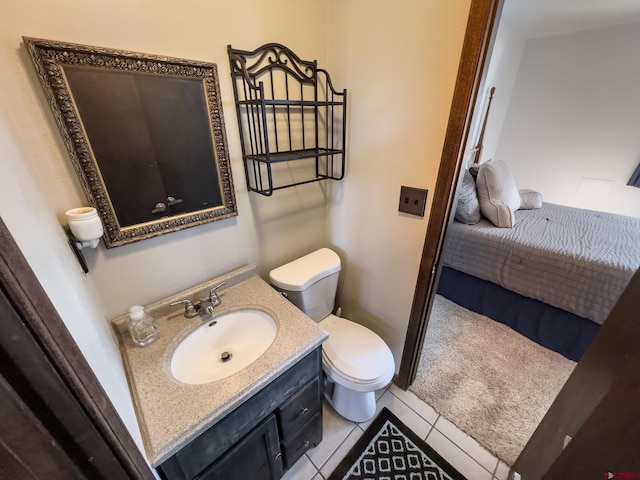 bathroom with toilet, vanity with extensive cabinet space, and tile flooring