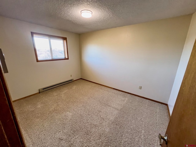 carpeted spare room featuring a textured ceiling and a baseboard heating unit