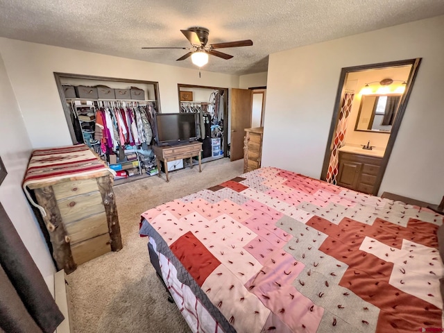 bedroom with a closet, ceiling fan, light carpet, a textured ceiling, and ensuite bathroom