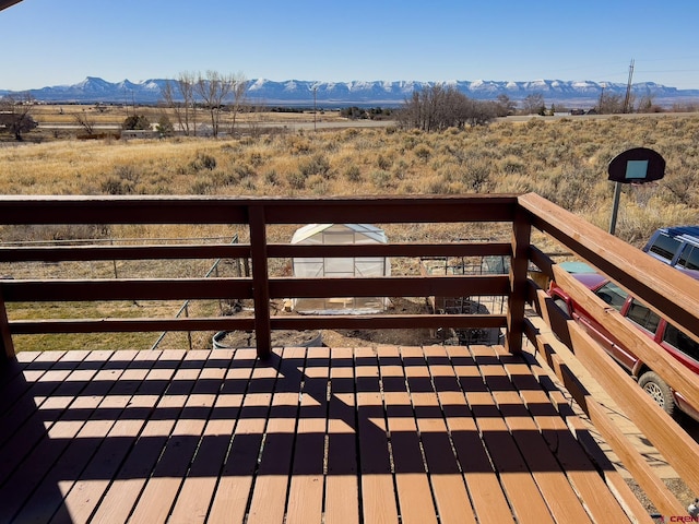 wooden terrace with a rural view and a mountain view