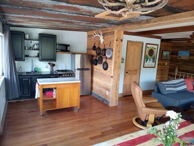 kitchen with dark hardwood / wood-style floors, stainless steel fridge, and wood walls