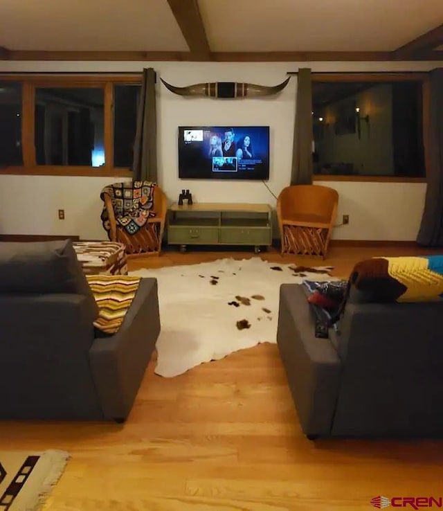 living room with light hardwood / wood-style floors and beamed ceiling