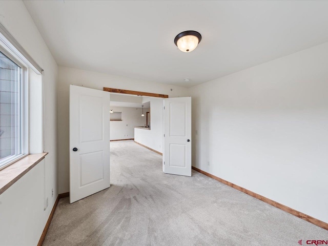 empty room featuring plenty of natural light and light carpet