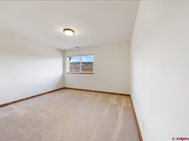 spare room featuring light colored carpet