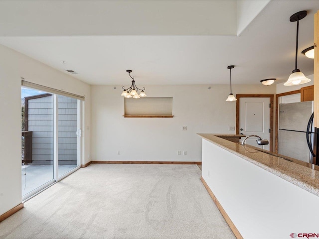 carpeted spare room with an inviting chandelier and sink