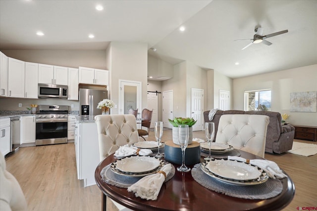 dining room with ceiling fan, light wood-type flooring, and high vaulted ceiling