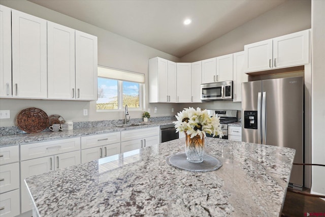 kitchen featuring appliances with stainless steel finishes, sink, light stone counters, and white cabinets