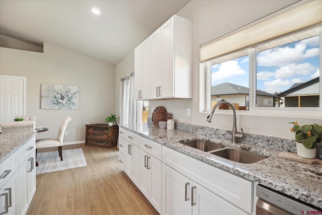 kitchen with white cabinetry, light hardwood / wood-style floors, sink, and light stone counters