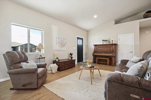 living room featuring lofted ceiling and light wood-type flooring